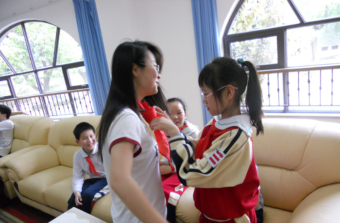 小学生为太阳成官网志愿者系红领巾